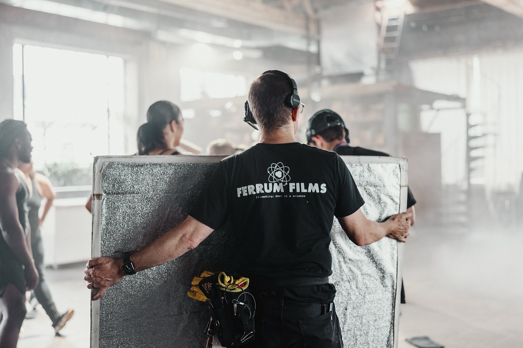A Ferrum Films crew member moving a large frame flag on set